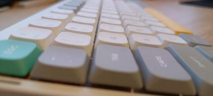 Белая клавиатура NuPhy Air75 V2 на деревянном столе.